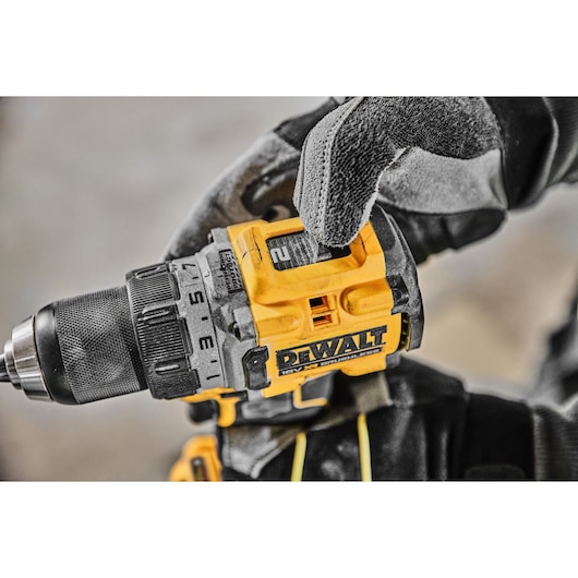 A gloved hand adjusting the speed setting on a DCD800P2T 18V XR Brushless Drill Driver