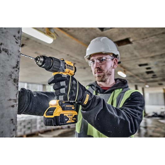 Construction worker drills into a wall using a DCD805P2T 18V XR Brushless Hammer Drill