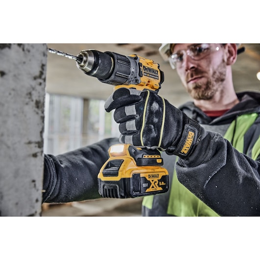 Construction worker drills into a wall using a DCD805P2T 18V XR Brushless Hammer Drill