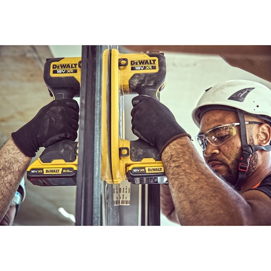 Construction worker attaches a Grabo 18V XR Suction Lifter to a pane of glass