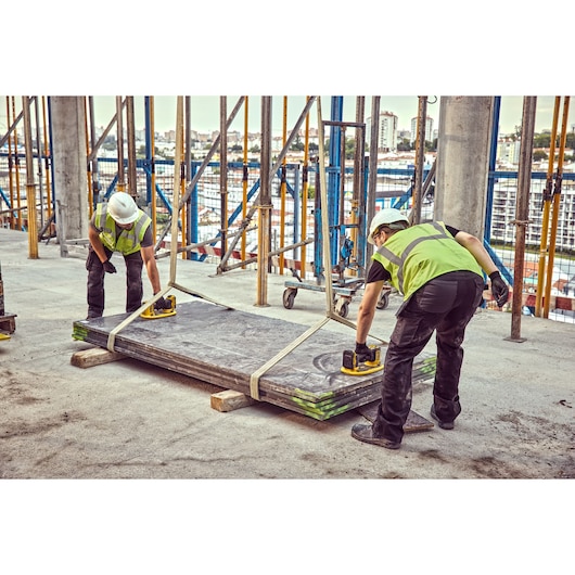 Two construction workers prepare to move timber sheets using Grabo 18V XR Suction Lifters 