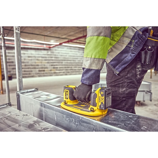 Construction worker attaches a Grabo 18V XR Suction Lifter to meta duct framework