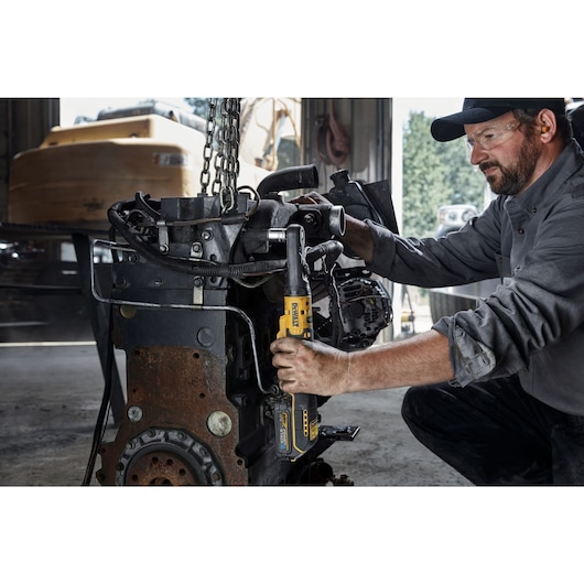 Mechanic using 12V MAX* XTREME™ Sealed Head Ratchet to tighten bolts on a vehicle engine