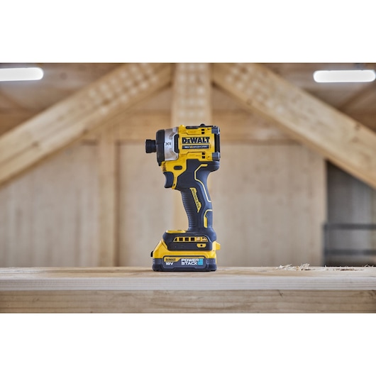 Side view of 18V XR 4 Speed Premium Impact Driver with Powerstack battery standing on wooden beam