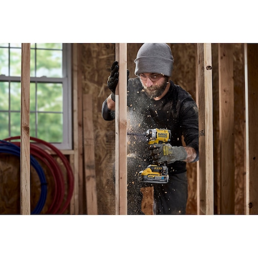 Worker using the 18V XR 4 Speed Premium Impact Driver on timber frame