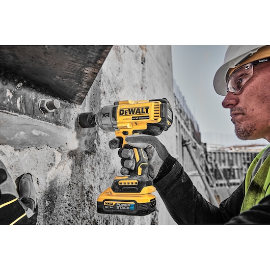 18V XR Brushless Impact Wrench 3/4 right close up view used by man on building site