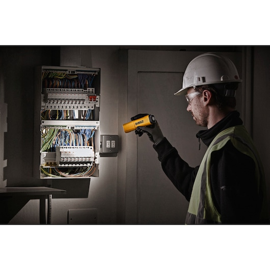 Rechargable USB LED Flashlight being held by workman checking fuse box in dim area