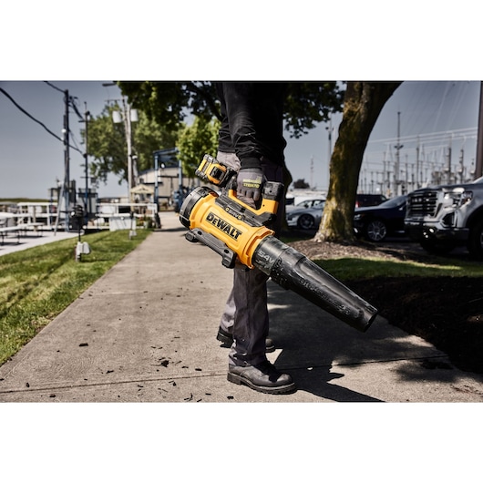 Worker standing on pavement holding 54V Axial Blower DCMBL777