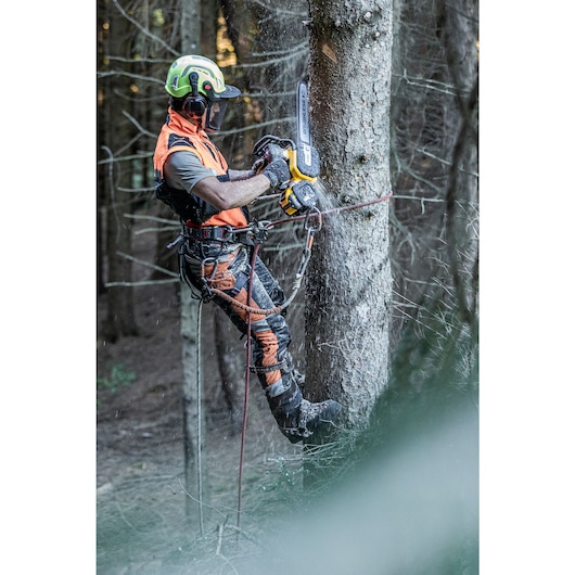 Arborist at height chopping tree with the DCMCST635 Top Handle Chainsaw