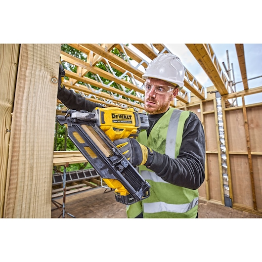 DCN930 18V XR Brushless framing nailer being used to drive nails into a wooden frame