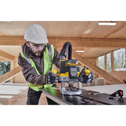 Construction worker using the 12mm plunge router on compact laminate