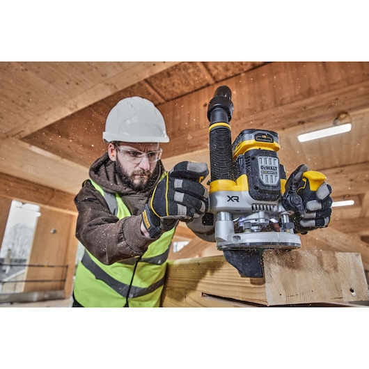 Worker on site using the 12mm plunge router on timber