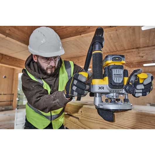 Construction worker using the 12mm plunge router edge attachment on timber