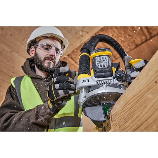 Construction worker using the 12mm plunge router on timber holding over moulded handles