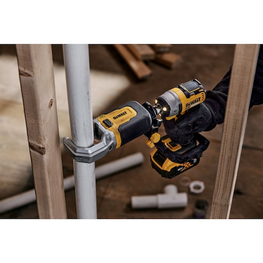 Impact Connect PVC/PEX pipe cutter attachment on Impact Driver cutting PVC pipe next to wood beam