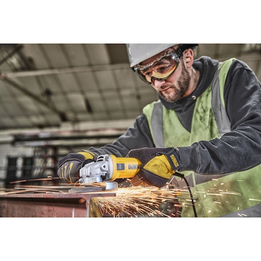 Worker uses DWE4036 angle grinder to grind metal, producing flying sparks