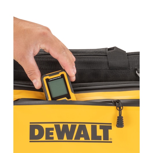 Close up of a LDM slotted into the front pocket on the Dewalt 16" Pro Open Mouth Tool Bag"